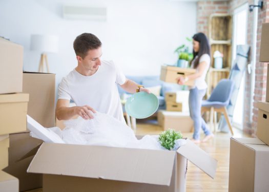 Young beautiful couple open cardboard boxes to order new home